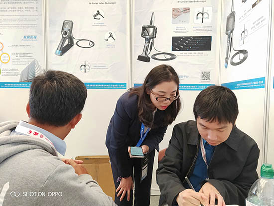 亞泰光電展臺前，公司內窺鏡工程師與客戶親密交談為